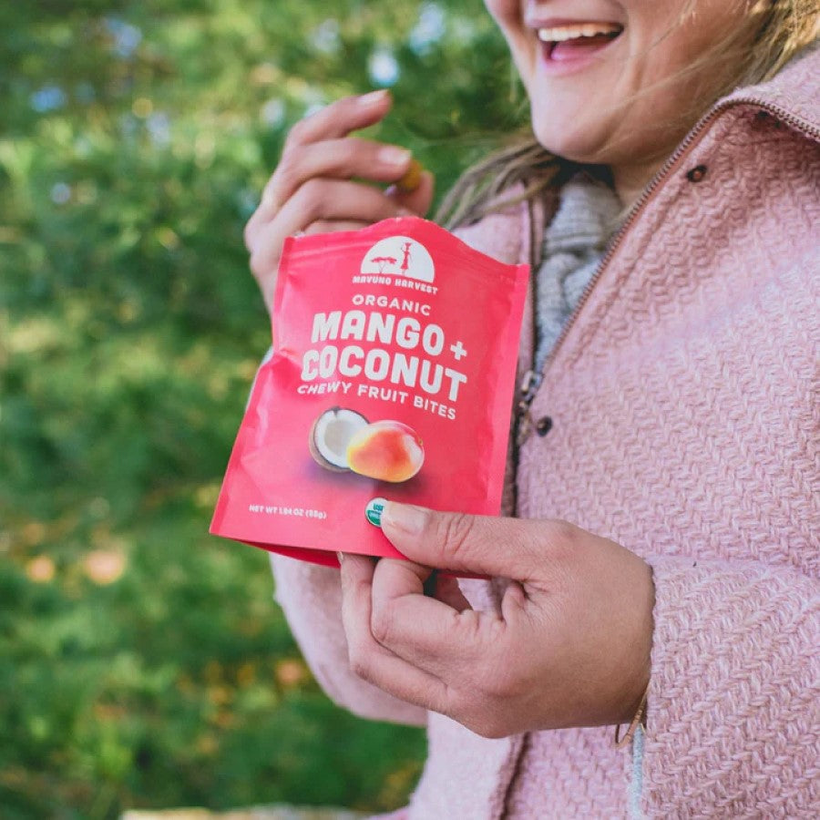 Woman Enjoying A Healthy Fruit Snack Outdoors Mavuno Harvest Mango Coconut Chewy Fruit Bites