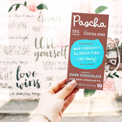 Hand Holding Pascha 55% Cacao Bar With Cocoa Nibs Mild Plus Crunchy Dream Team Organic Dark Chocolate
